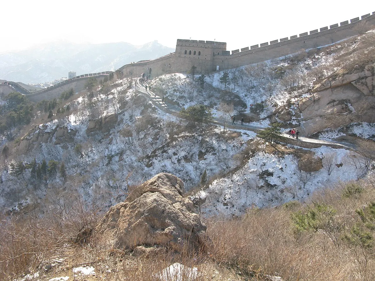 Trecho da Muralha da China com uma torre sobre a crista de uma montanha com neve em Badaling.