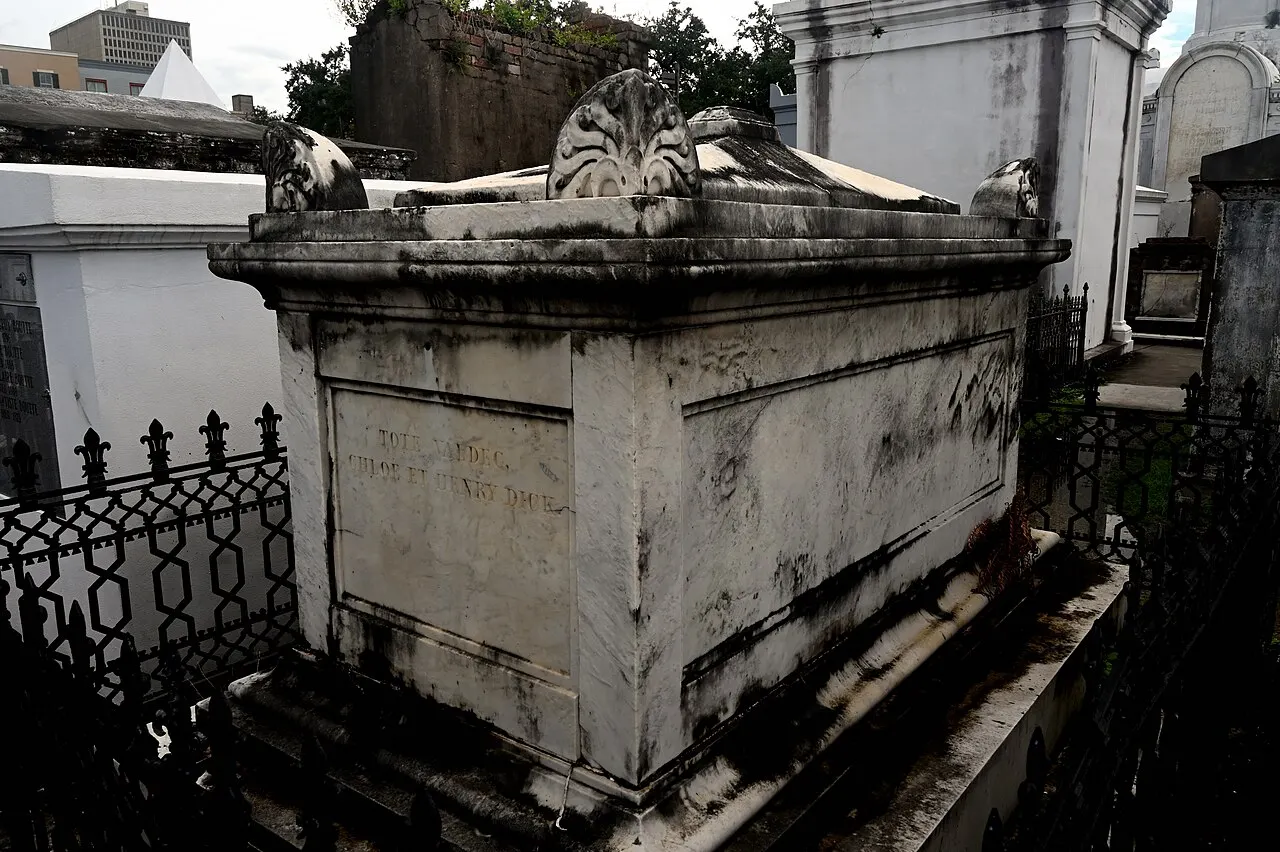 Túmulo de alvenaria caiada, com frontão, no Cemitério St. Louis No. 1, em Nova Orleans.