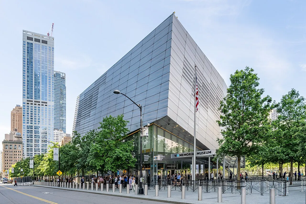 Le pavillon de verre incliné du musée du 11-Septembre, à New York, avec les arbres du mémorial devant.