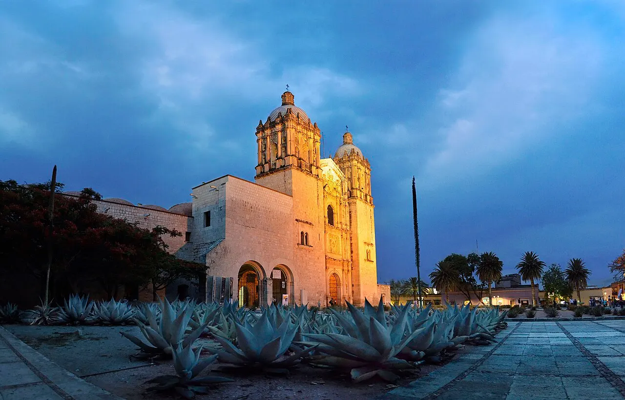 Templo de Santo Domingo de Guzmán, em Oaxaca, com as duas torres, iluminado ao anoitecer.