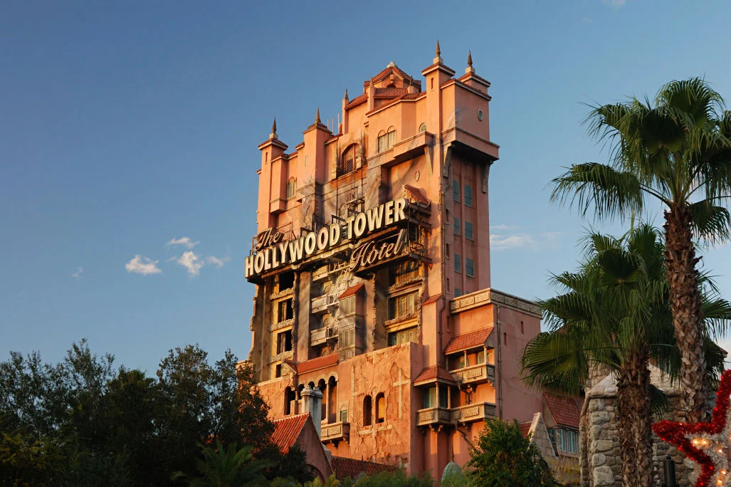 Fachada alaranjada do Hollywood Tower Hotel no Disney’s Hollywood Studios em 2007, com o letreiro e palmeiras cobrindo parte da base.