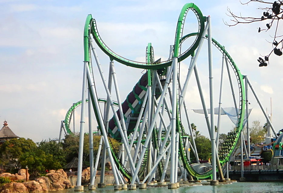 Trilhos verdes e suportes brancos da montanha-russa The Incredible Hulk Coaster sobre a água no Islands of Adventure em 2011, com um trem distante no circuito.