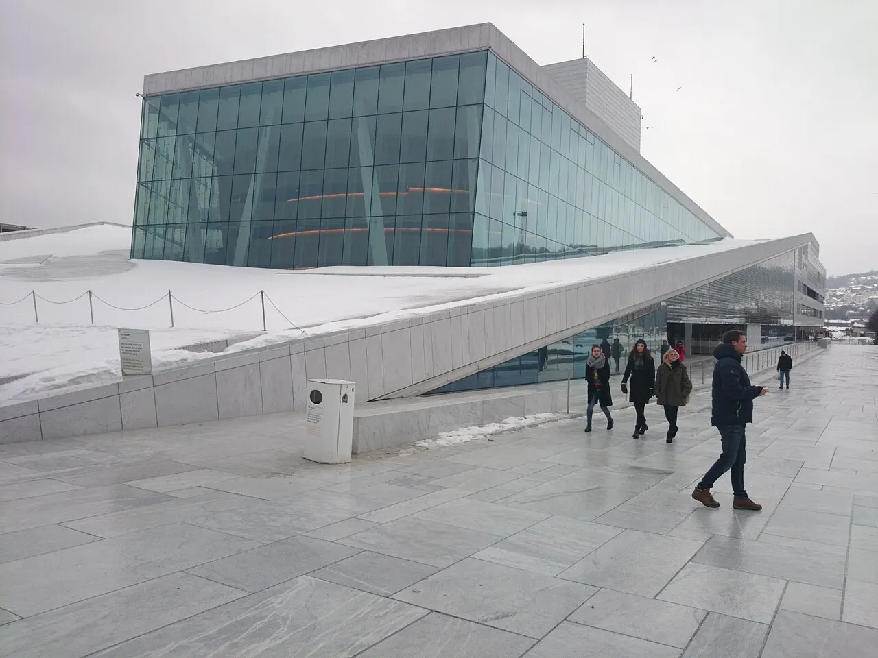 L'opéra d'Oslo, avec son toit blanc incliné qui descend jusqu'au sol, en hiver.