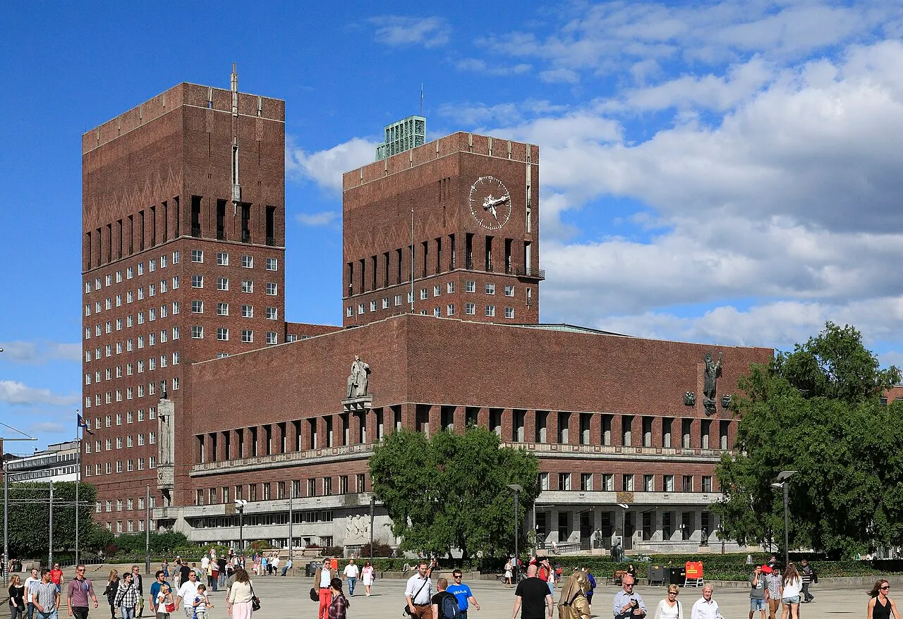 Prefeitura de Oslo, de tijolo marrom, com as duas torres quadradas, vista de Aker Brygge.
