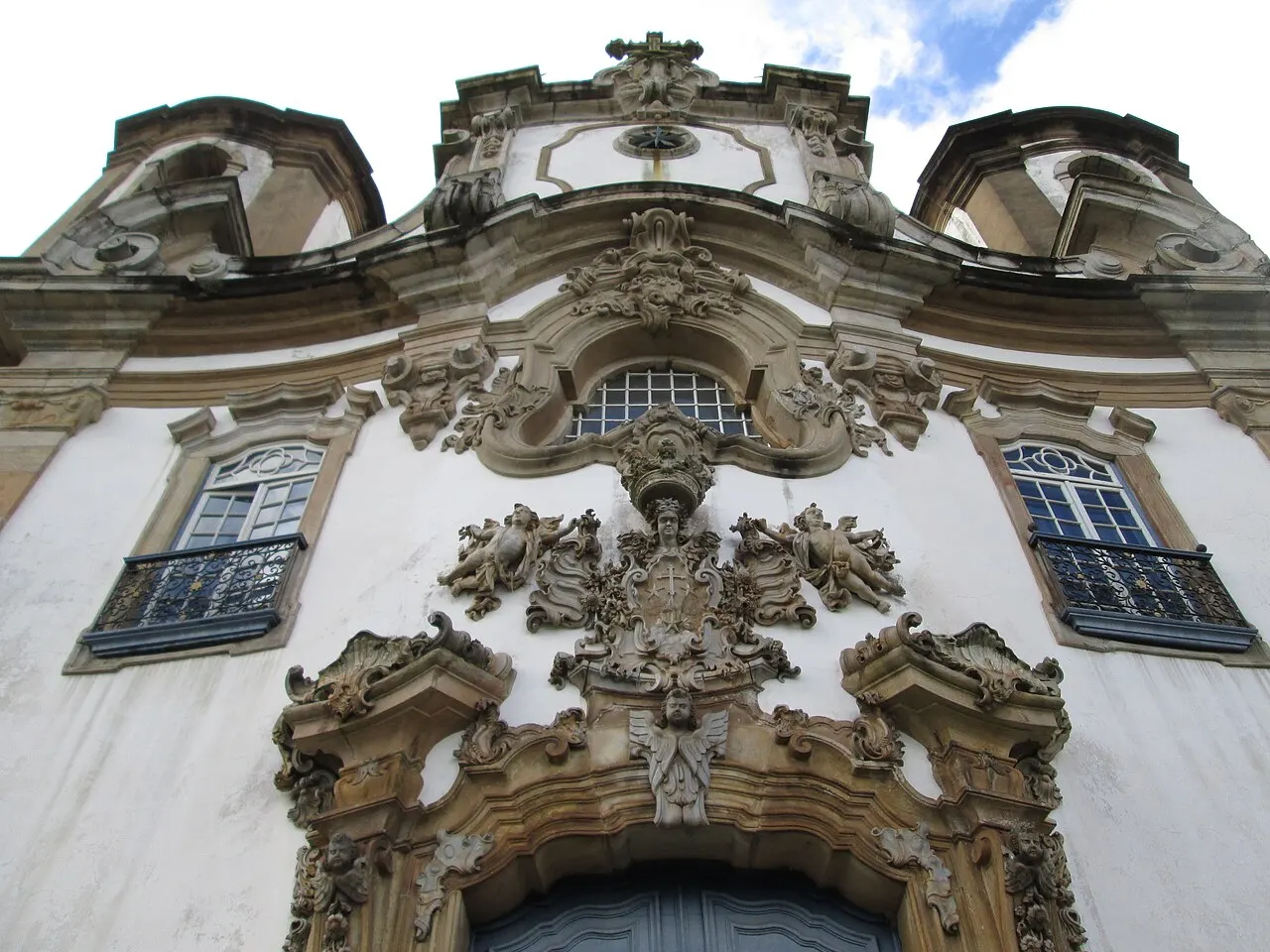 Detalhe da fachada da Igreja de Nossa Senhora do Carmo, em Ouro Preto, com ornamentos esculpidos em pedra-sabão sobre a porta e entre as janelas.