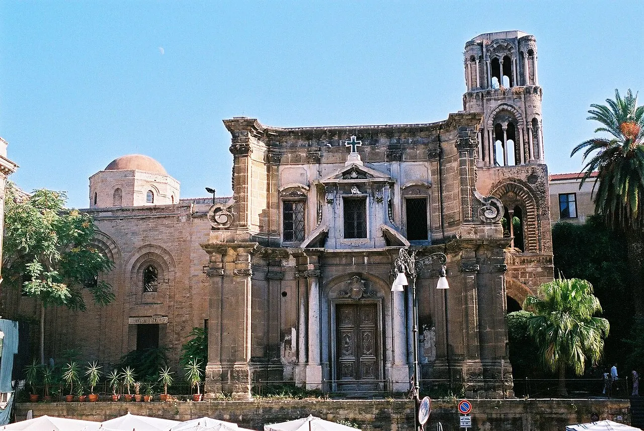 La iglesia de la Martorana con la fachada barroca de piedra, la cúpula al lado y el campanario normando de arcos a la derecha.