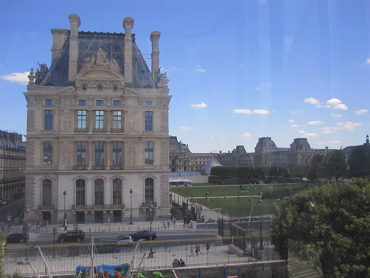 Pavilhão de pedra clara com telhado de ardósia e chaminés altas, na ponta do Louvre junto às Tulherias.