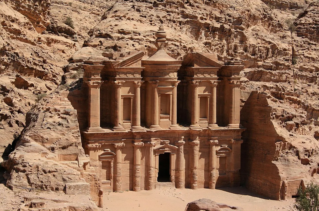Fachada do Mosteiro de Petra, Ad-Deir, esculpida na rocha rosada, com colunas e a urna no alto.