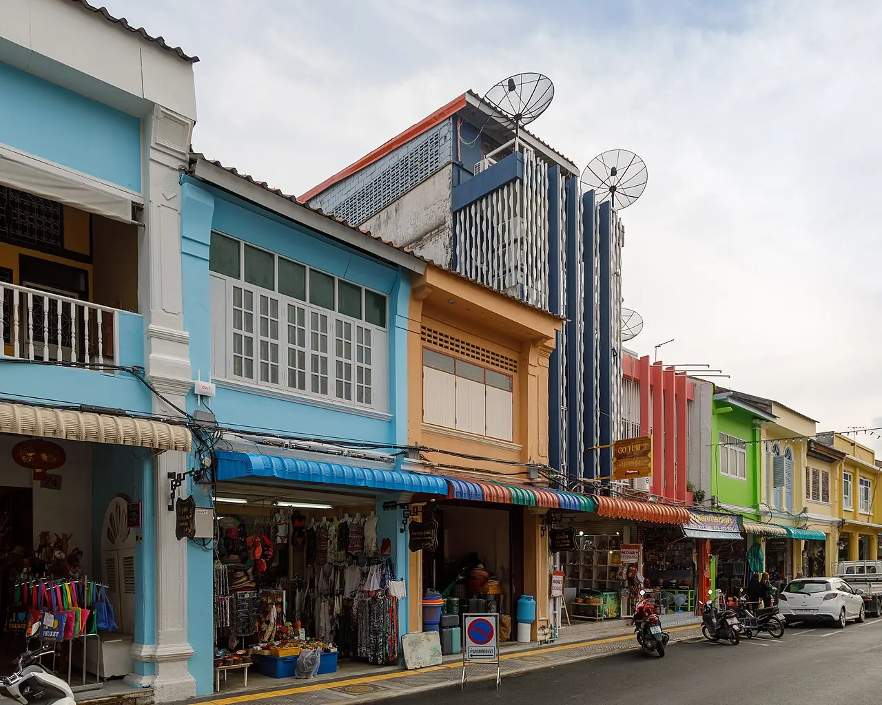 Sobrados sino-portugueses pintados de azul, laranja e verde na Thalang Road, na cidade velha de Phuket, com lojas no térreo.