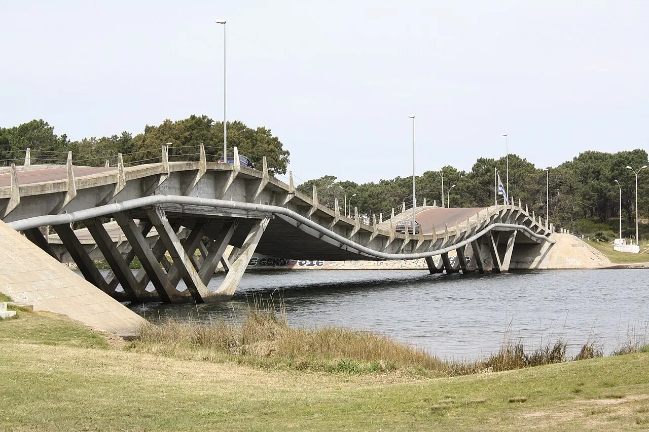 A ponte Leonel Viera sobre o arroio Maldonado, com o tabuleiro em ondas apoiado em pilares de concreto em V, e mato na margem.