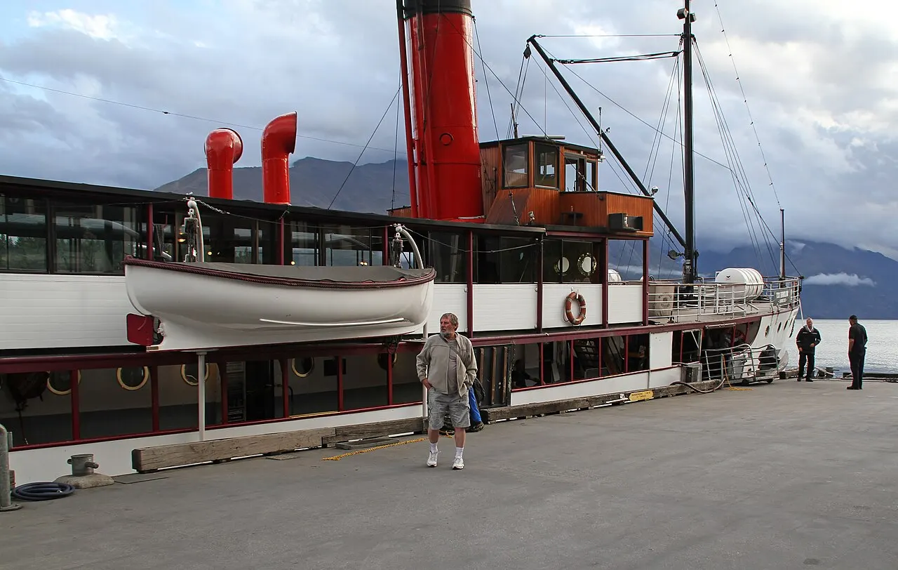 O vapor TSS Earnslaw atracado no cais de Queenstown, com a chaminé vermelha.