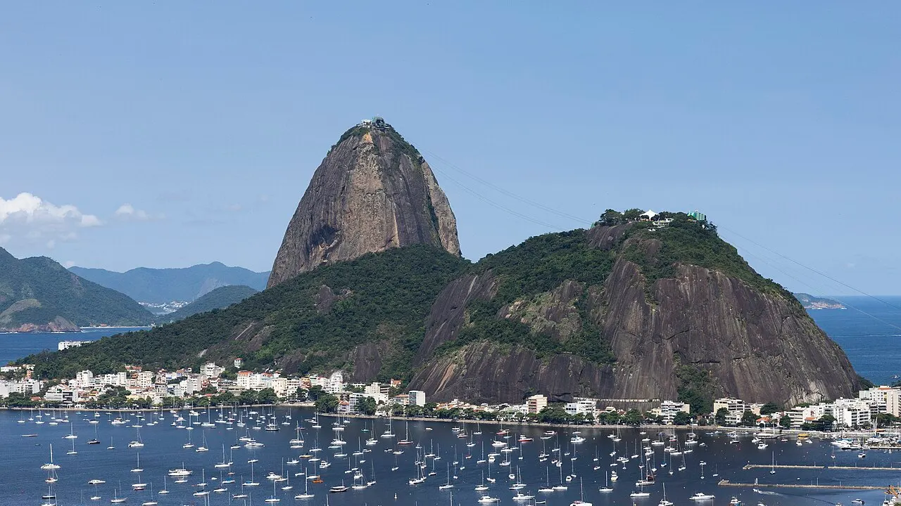 Pão de Açúcar e o Morro da Urca vistos do outro lado da baía, com barcos ancorados à frente.