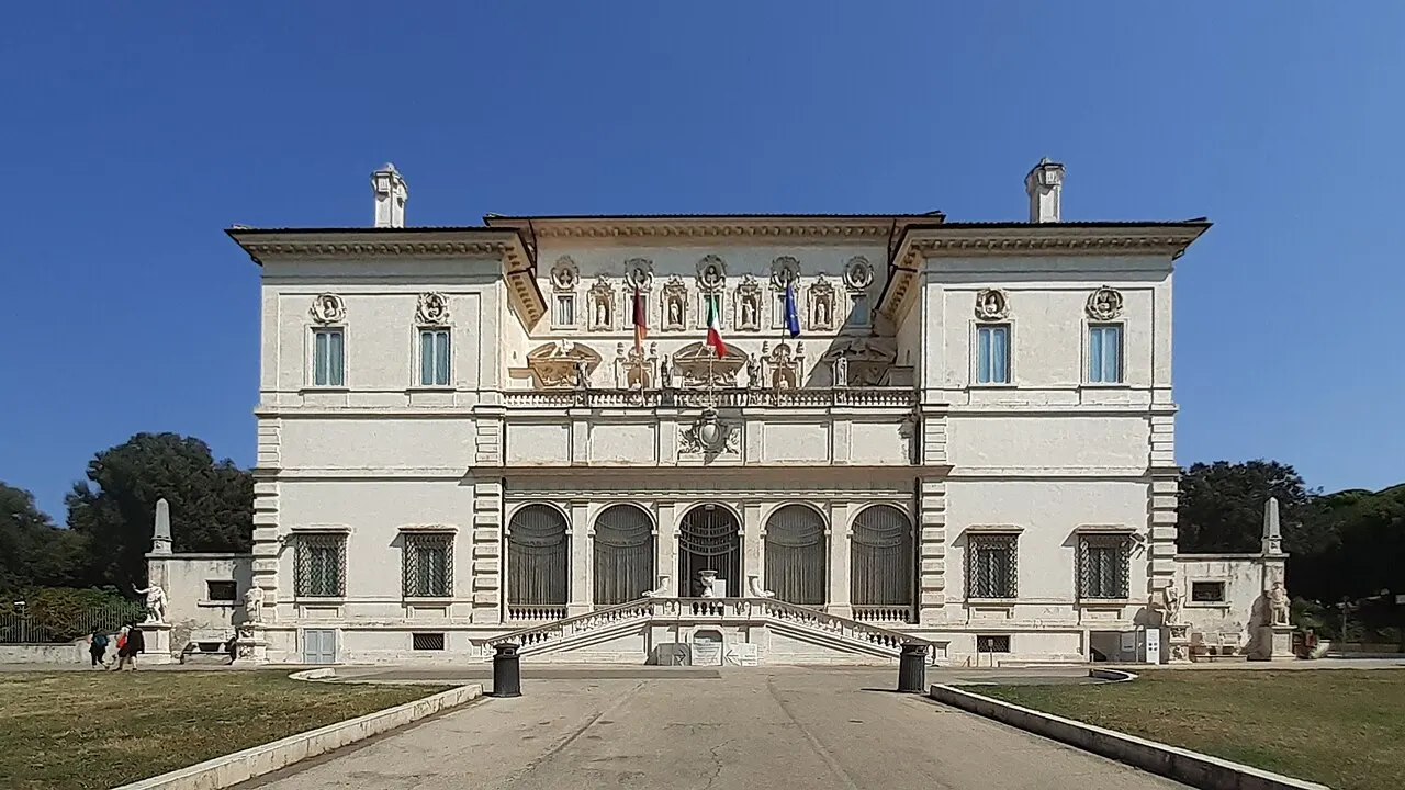 Fachada do Casino Borghese, sede da Galleria Borghese, em Roma, com a escadaria dupla, sob céu azul.