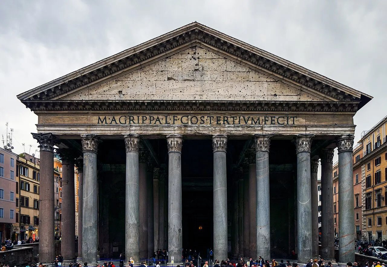 Pórtico do Panteão, em Roma, com as colunas de granito e a inscrição no frontão, visto de frente.