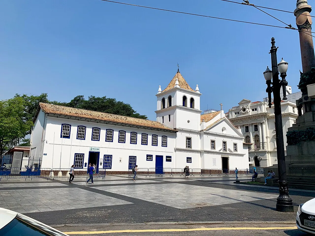 Conjunto branco do Pátio do Colégio, em São Paulo, com a torre da igreja e a fachada comprida.
