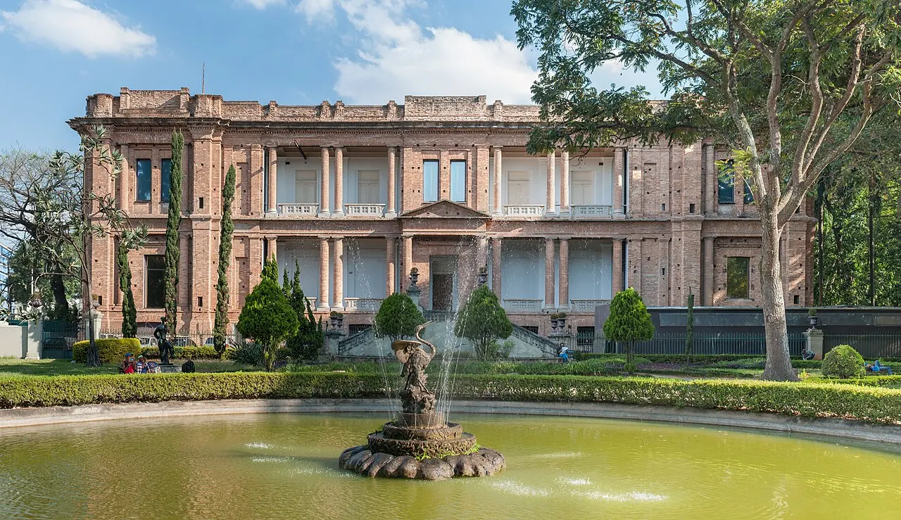 Prédio de tijolo aparente da Pinacoteca do Estado, em São Paulo, atrás do espelho d'água do jardim.