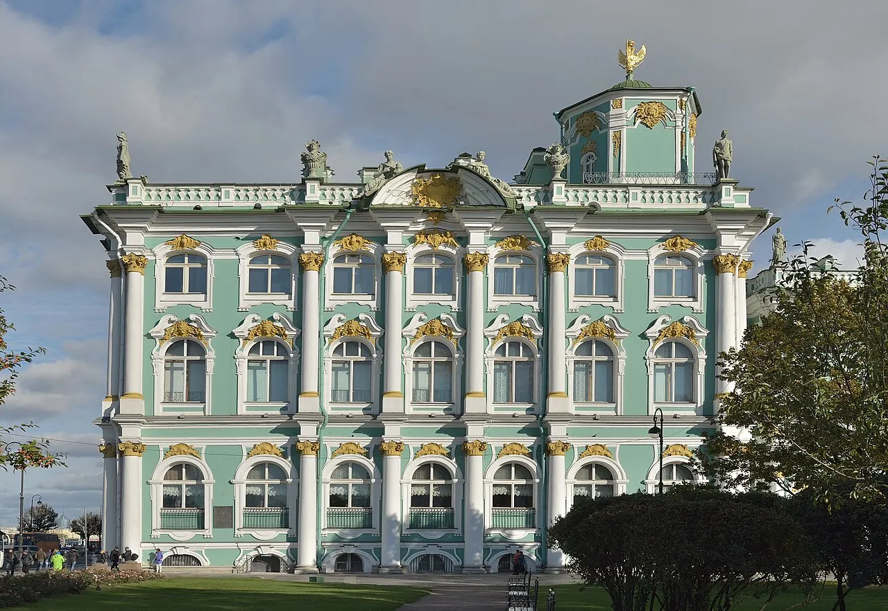 Fachada verde e branca do Palácio de Inverno, sede do Ermitage, em São Petersburgo, com as estátuas no alto.