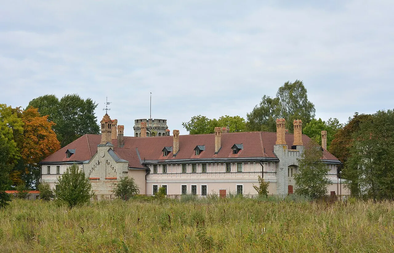 Palacete de Maarjamäe, em Tallinn, casa comprida de telhado vermelho, vista do capim alto.