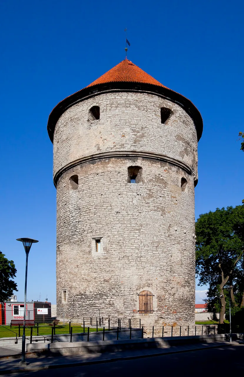 Torre redonda Kiek in de Kök, em Tallinn, de pedra clara, com telhado cônico vermelho.