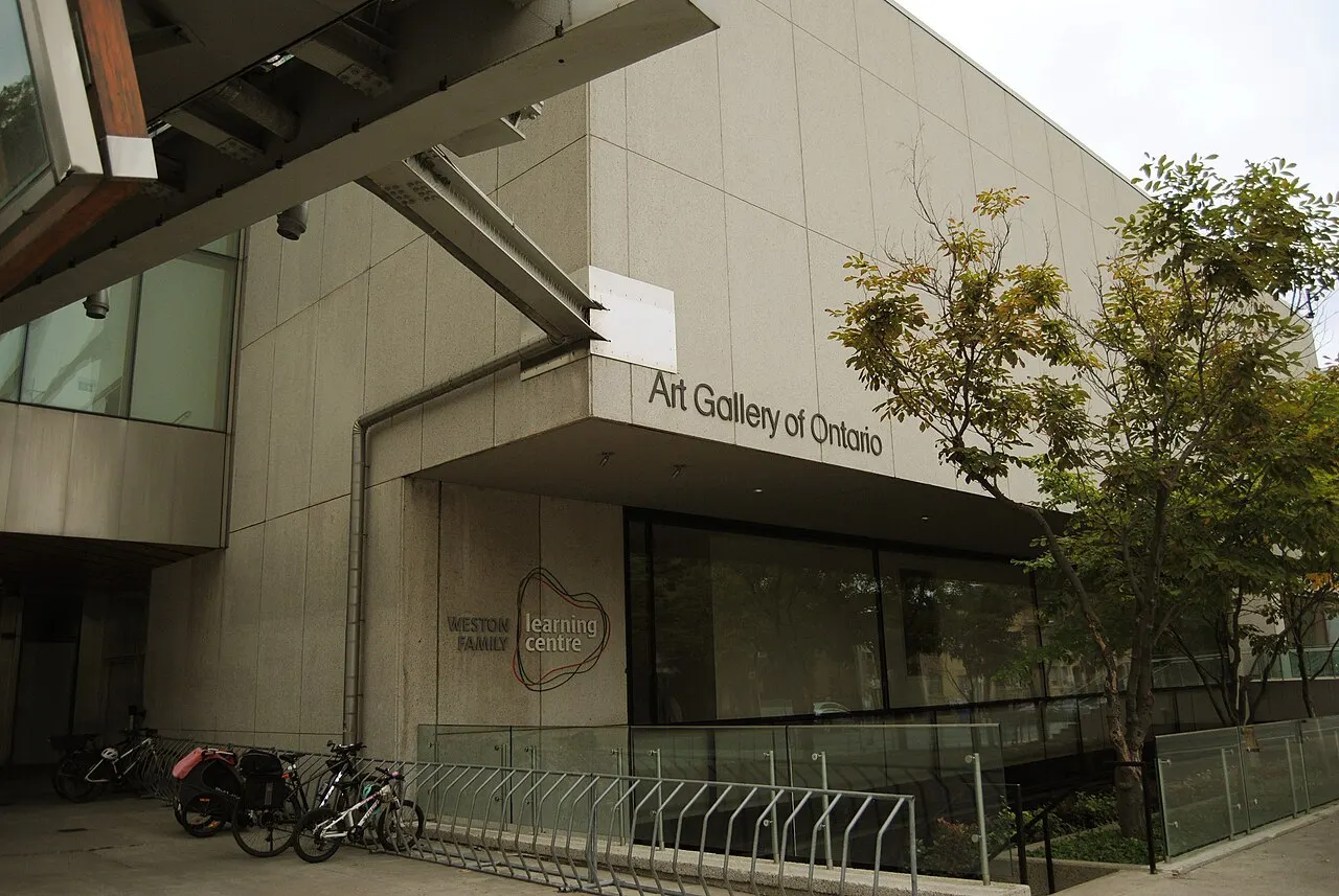 Entrada moderna do Art Gallery of Ontario, com o nome do museu na fachada e bicicletas estacionadas na calçada.