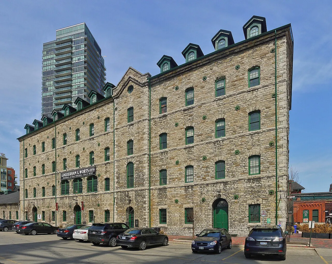 Prédio de tijolo da antiga destilaria, no Distillery District de Toronto, com janelas em arco e portas verdes.