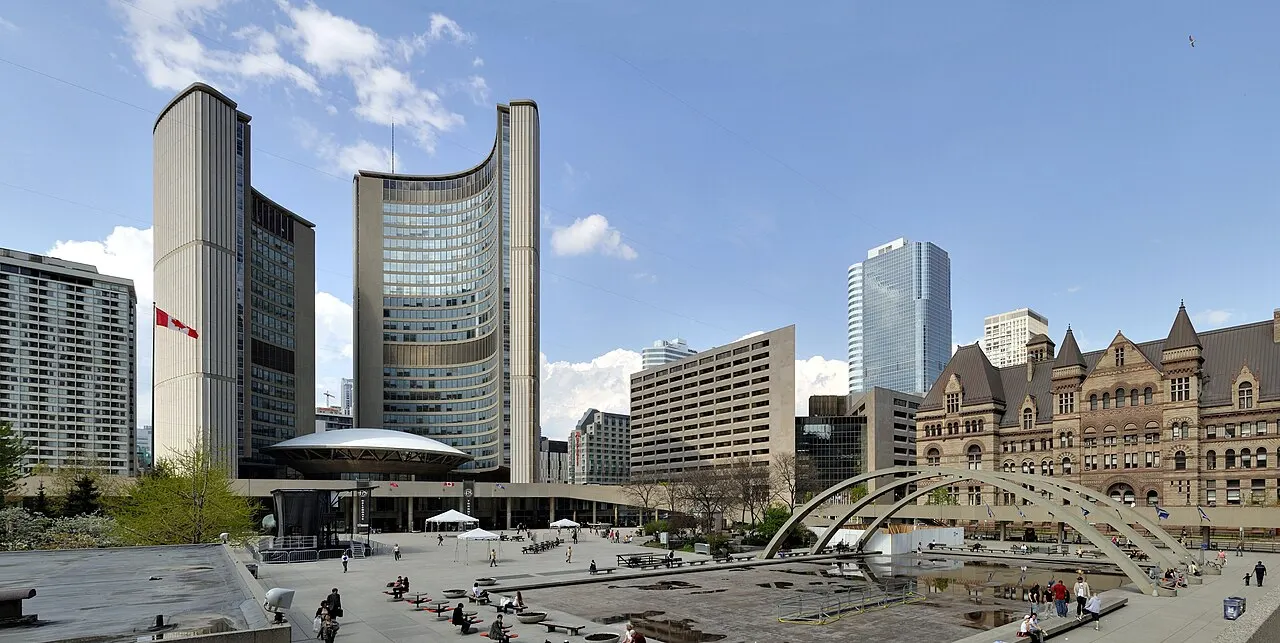 A Nathan Phillips Square, com as duas torres curvas da prefeitura nova e o prédio antigo de pedra à direita.