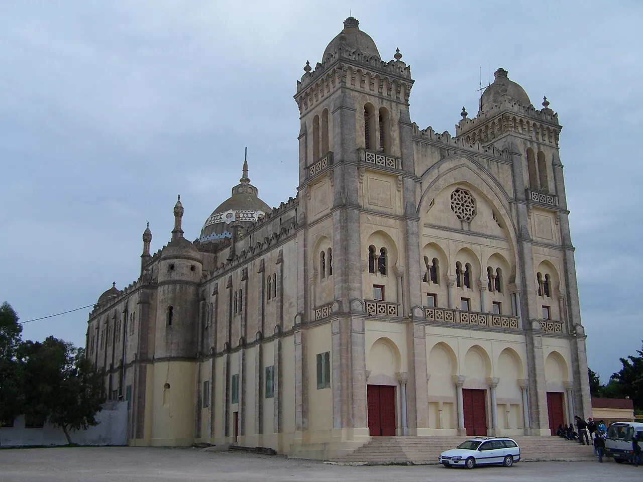 Acropolium de Cartago, a antiga Catedral de São Luís, com as torres e a cúpula, sob céu nublado.