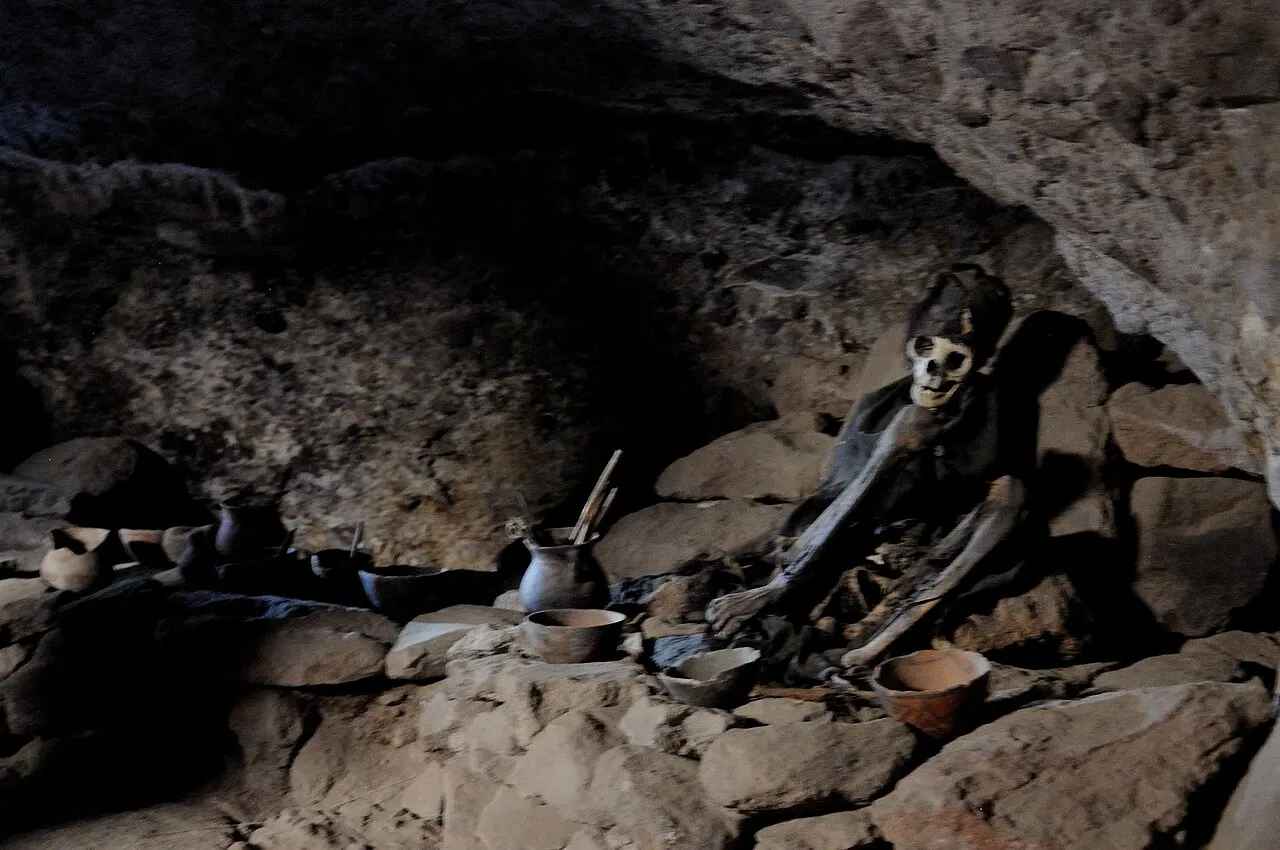 Restos mumificados e objetos de barro em uma caverna de rocha escura perto de Coquesa, no vulcão Tunupa.