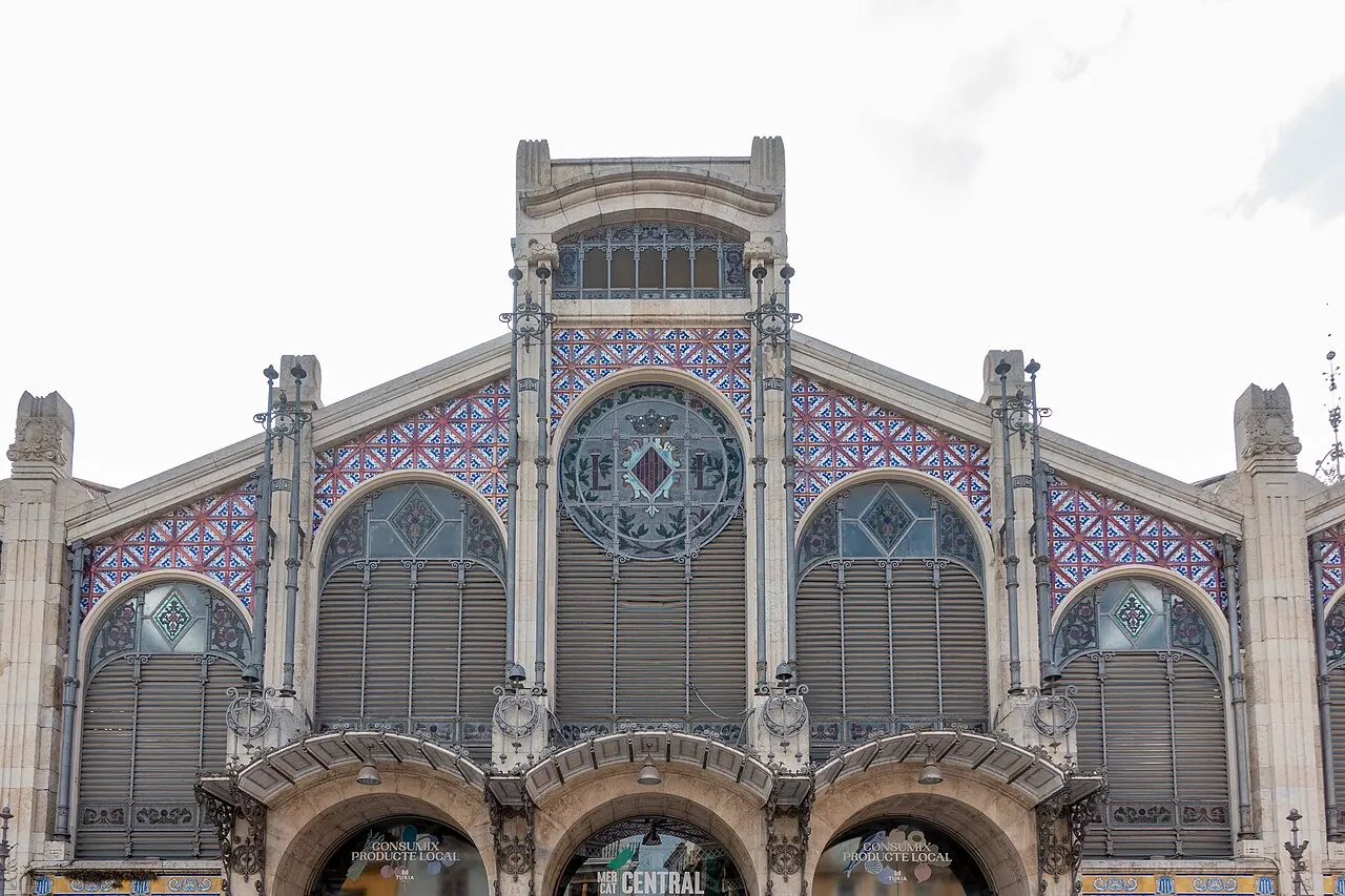 A fachada do Mercado Central de Valência, com arcos de ferro e vidro, rosácea e faixas de cerâmica colorida.