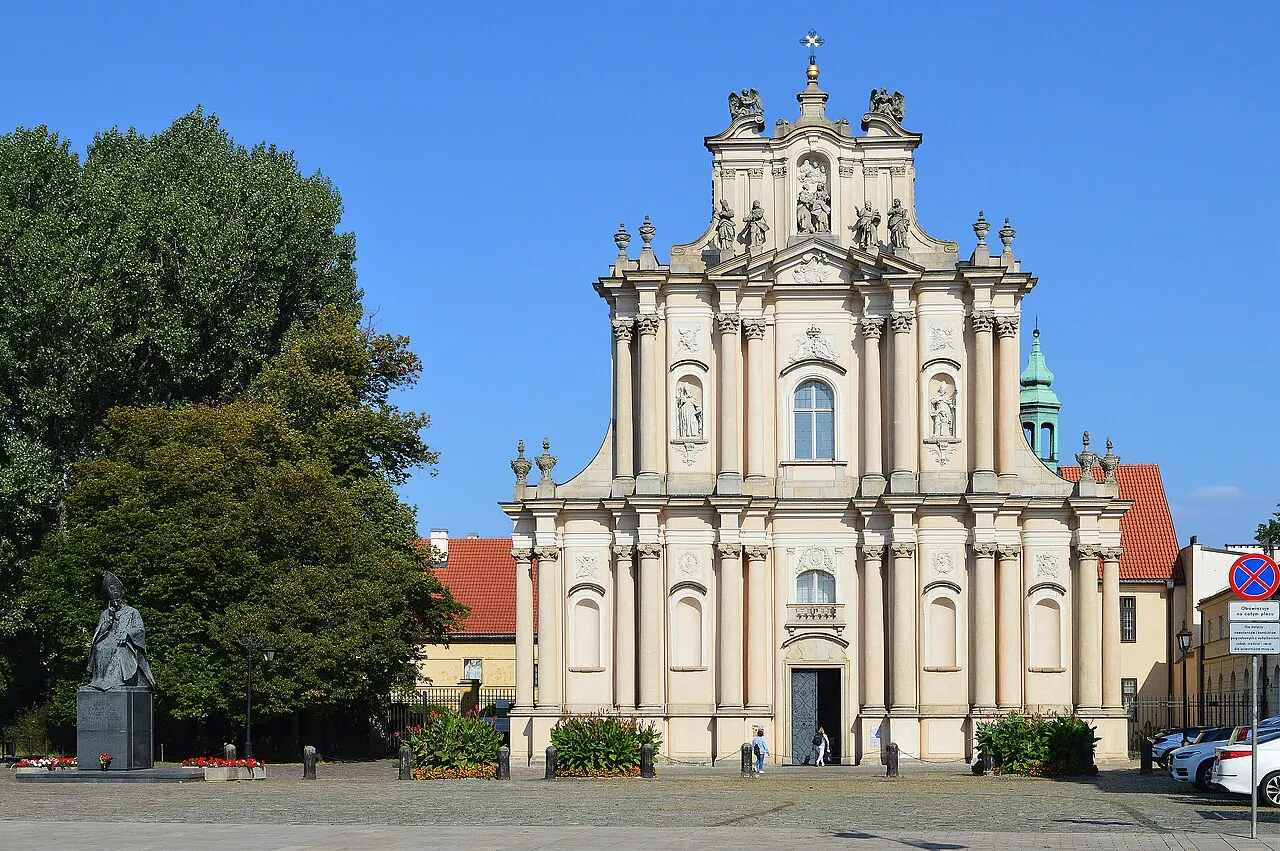 Fachada barroca da Igreja das Visitandinas, na rua Krakowskie Przedmieście, em Varsóvia, sob céu azul.