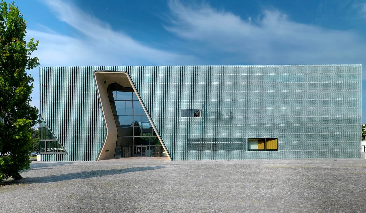 Prédio de vidro do Museu POLIN, em Varsóvia, com a fenda curva que corta a fachada.