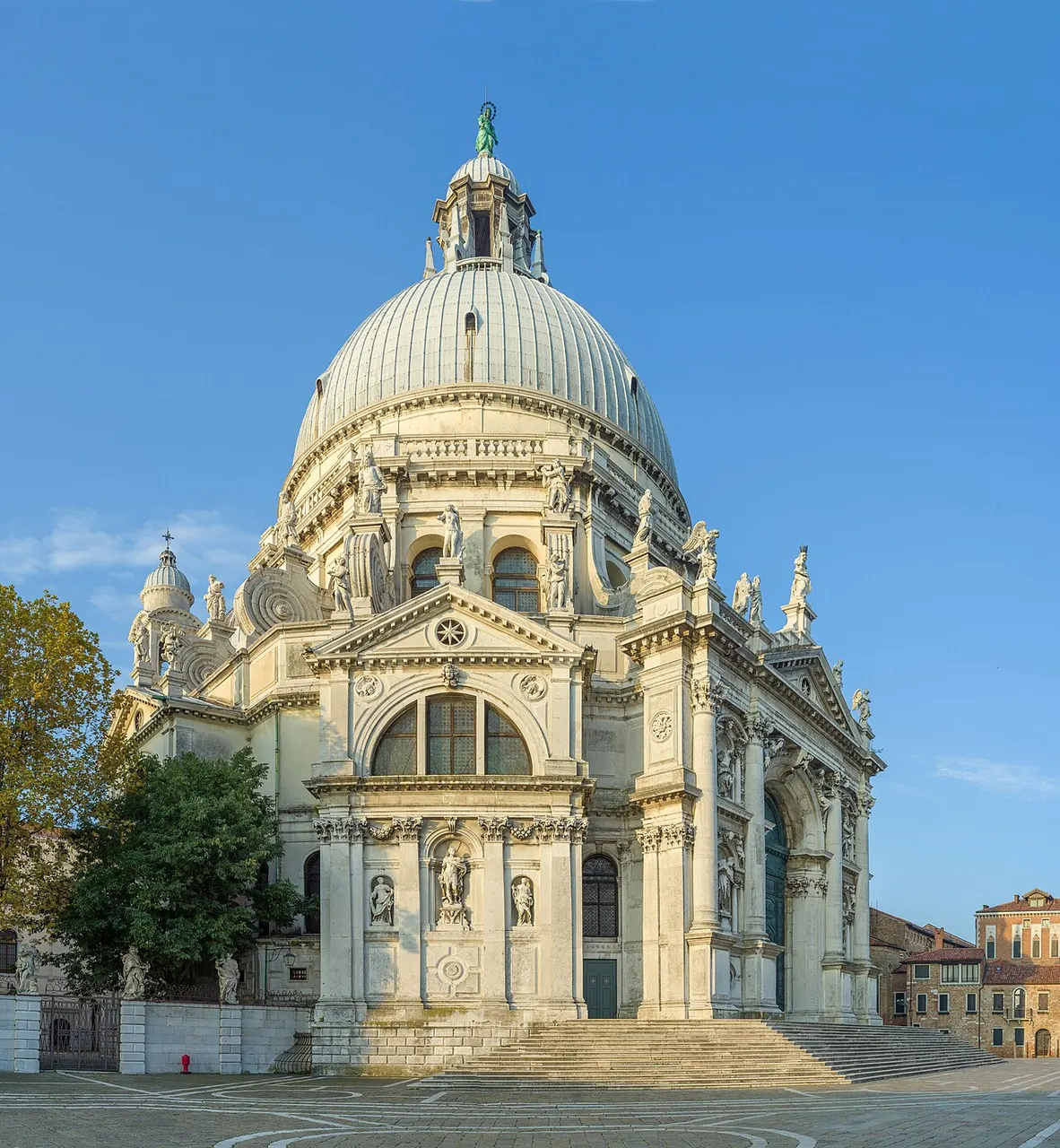 Basílica de Santa Maria della Salute, em Veneza, com a grande cúpula e as volutas, sob céu azul.