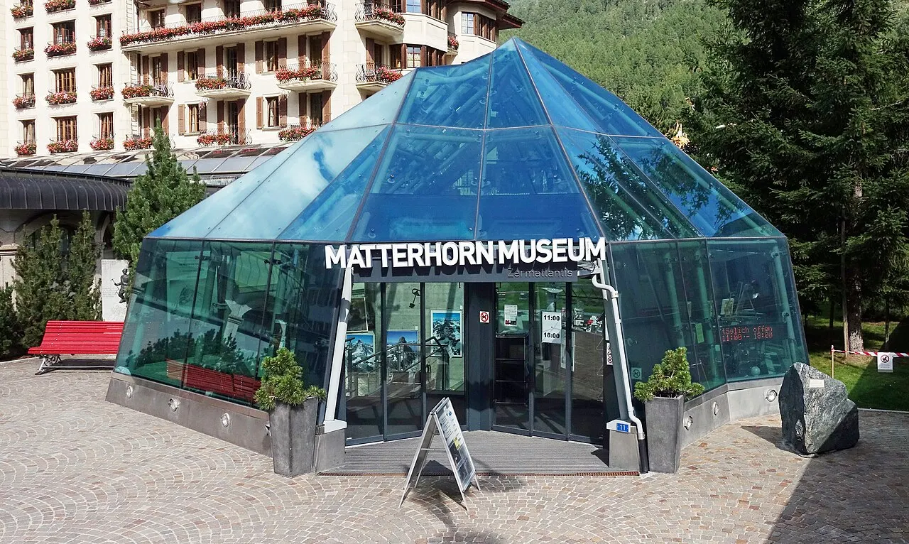 O pavilhão de vidro azulado em forma de tenda que dá entrada ao Matterhorn Museum, numa praça de Zermatt.