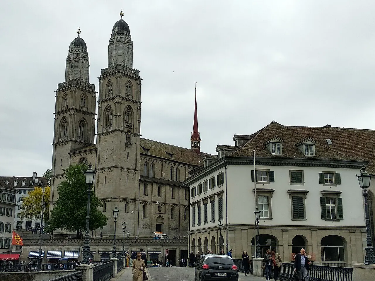 Grossmünster, em Zurique, com as duas torres gêmeas de cúpula baixa, ao lado de prédios da margem.