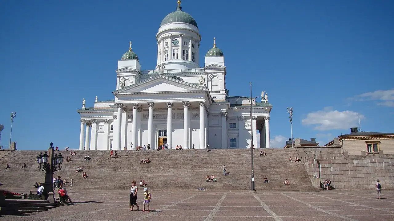 Catedral Luterana de Helsinque, branca com cúpulas verdes, no alto da escadaria da Praça do Senado.