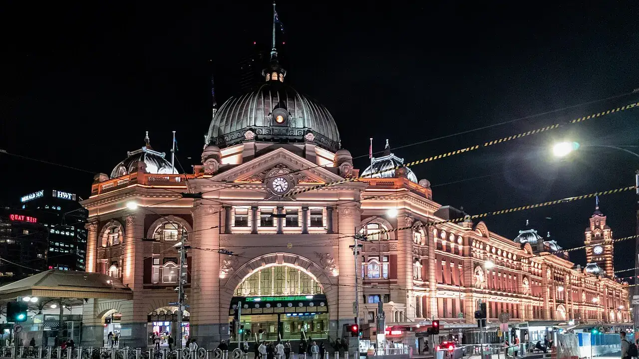 A estação Flinders Street iluminada à noite, com a cúpula sobre a entrada.