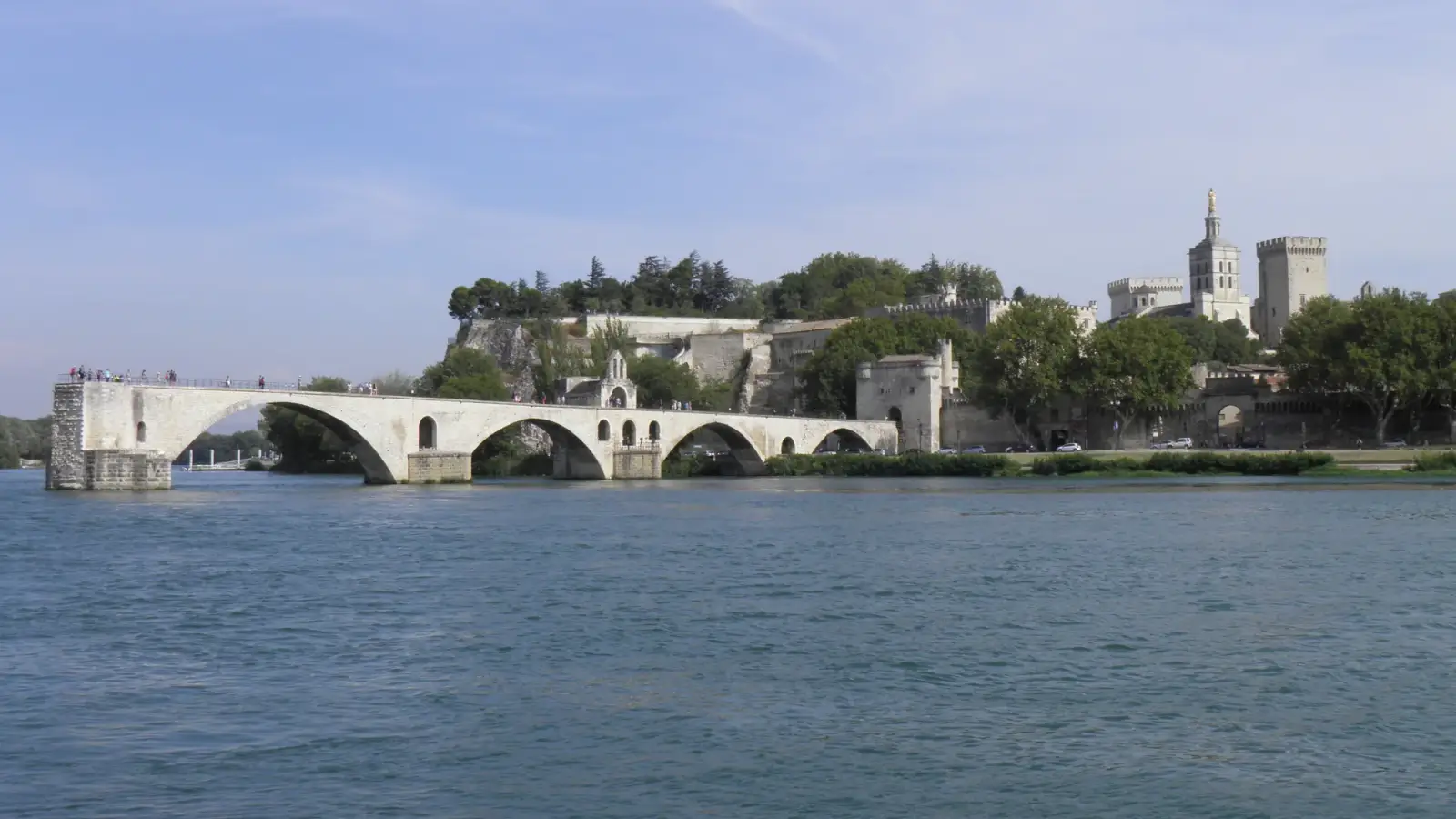 Pont Saint-Bénézet sobre o Ródano, com Avignon e o Palais des Papes ao fundo.