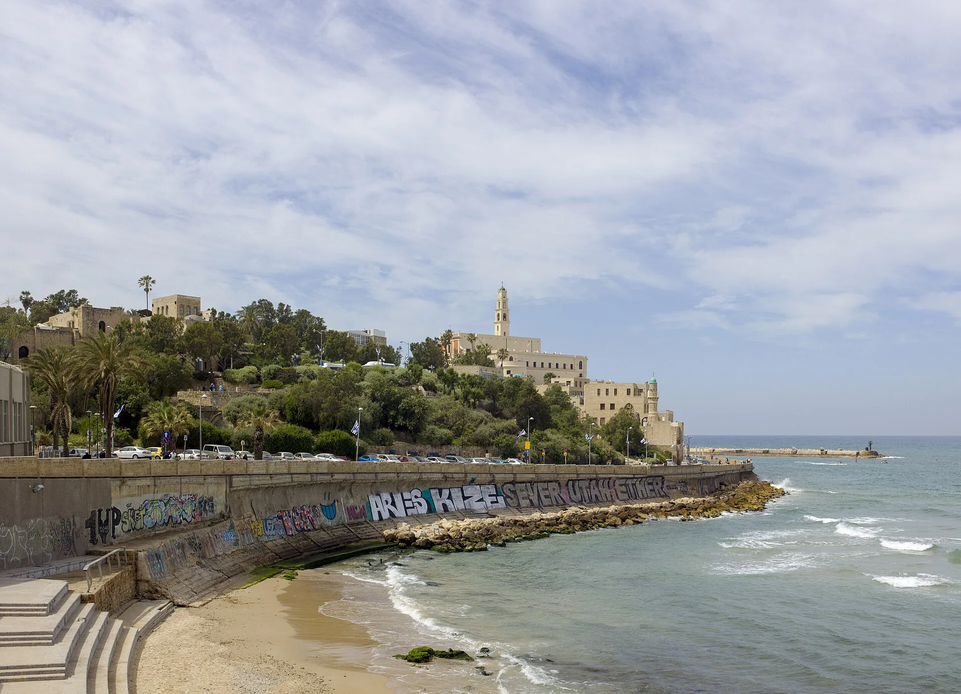 A cidade velha na colina, o mar e a muralha da orla.