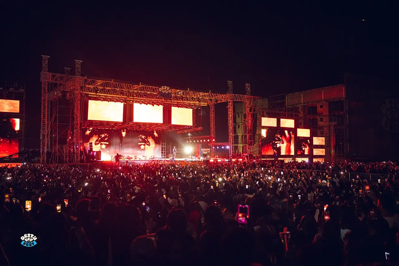 Une scène éclairée en rouge et un large public de nuit au Detty December Fest 2025, à Accra.