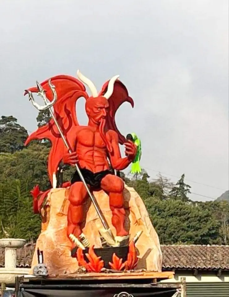 Grande figura vermelha de diabo com asas, chifres e tridente, preparada para a Quema del Diablo em Antigua Guatemala.