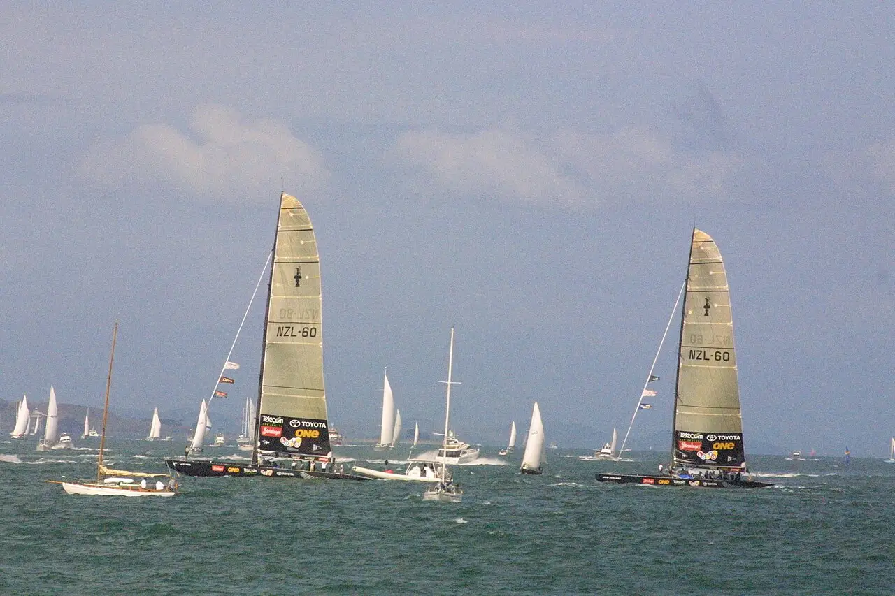 Veleiros com velas brancas e escuras navegando no porto de Auckland durante a regata do Anniversary Day de 2001.