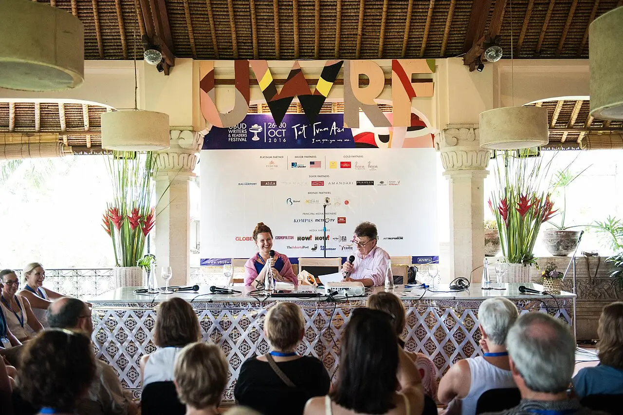 Debate em uma mesa sob um pavilhão aberto com telhado de madeira, com o público sentado à frente, no Ubud Writers & Readers Festival de 2016.
