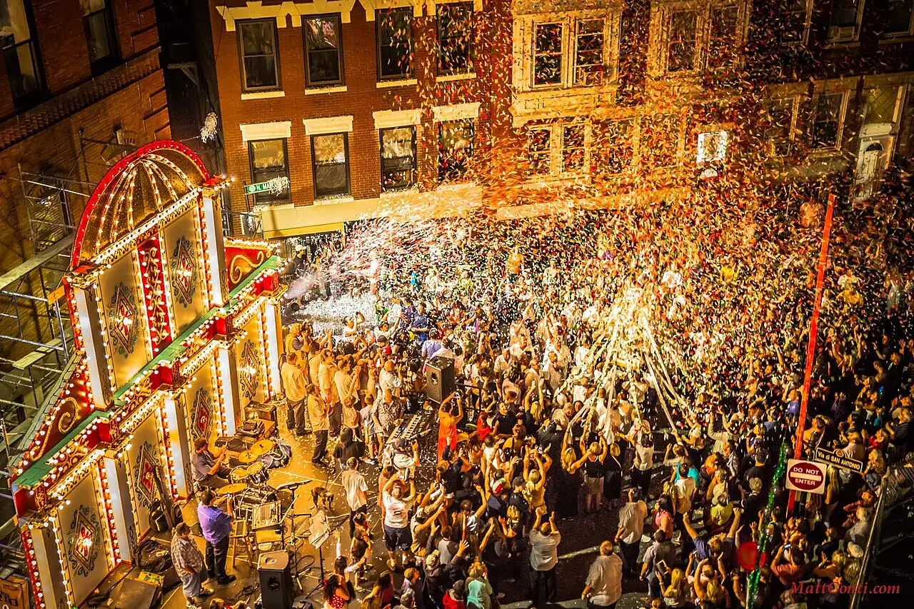 Multidão vista do alto em uma rua do North End com arcos de luzes e confete no ar durante a festa de Santo Antônio de 2013.