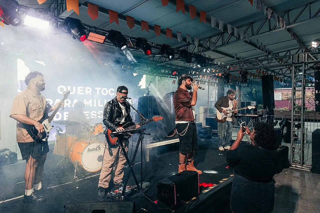 Banda toca sob uma estrutura de palco coberta, com luzes e fumaça, no Porão do Rock de 2026.