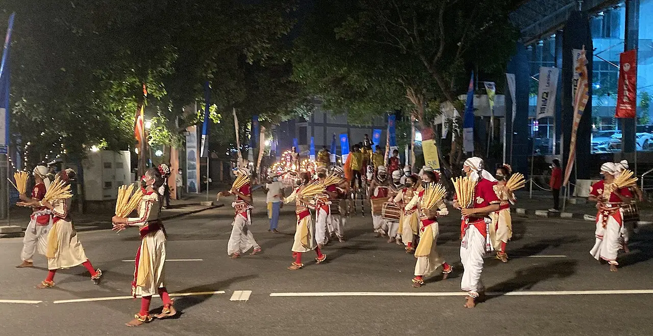 Des danseurs en tenue traditionnelle défilent de nuit dans une rue de Colombo lors du Navam Perahera du temple Gangarama, en 2022.