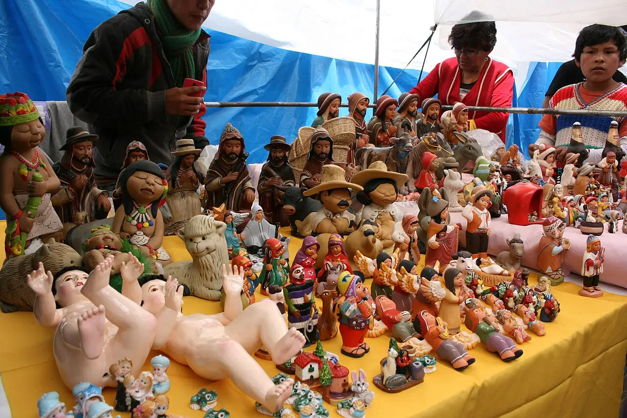 Bancada do Santurantikuy em Cusco, em 2015, com figuras de barro do presépio em fileiras sob uma lona azul.
