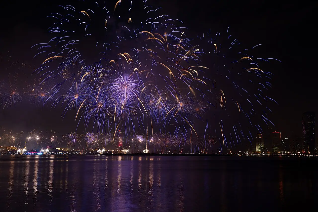 Fogos de artifício roxos e vermelhos explodem sobre a água, à noite, durante as comemorações do Dia Nacional do Catar em Doha, em 2018.