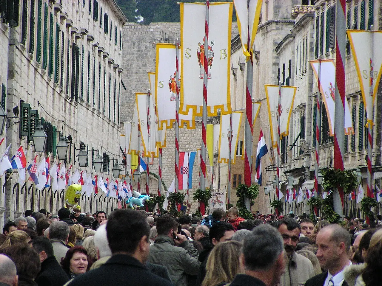 Multidão numa rua de Dubrovnik decorada com estandartes e bandeiras brancas e vermelhas durante a festa de São Brás, em 2008.