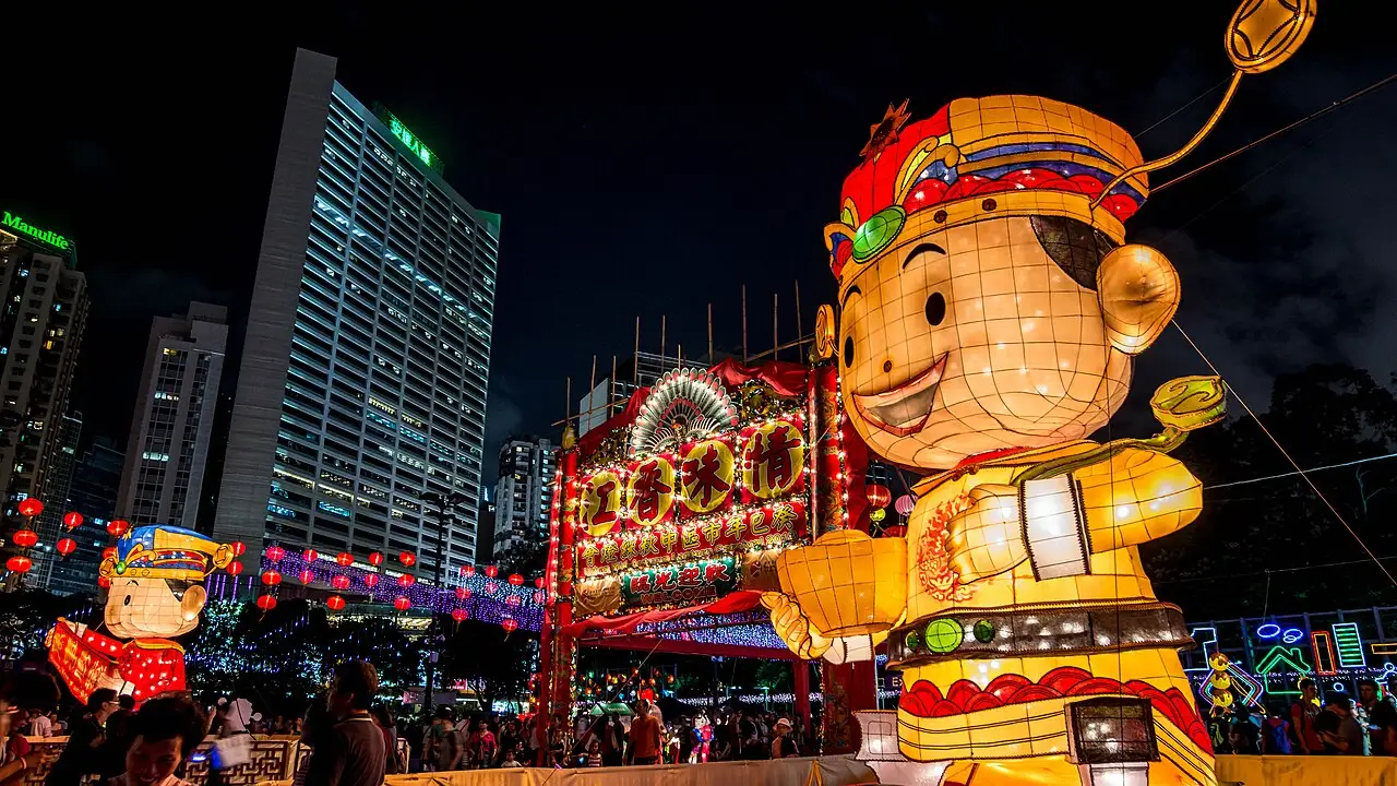 Grande lanterna iluminada em forma de figura sorridente, com prédios e letreiros acesos ao fundo, no Festival do Meio do Outono de 2013.