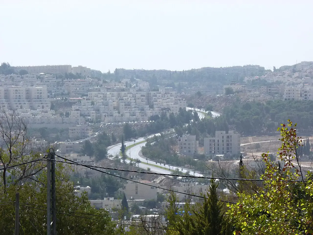 Via curva sem carros, cercada por árvores e prédios nas colinas de Gilo, fotografada durante o Yom Kippur de 2011.